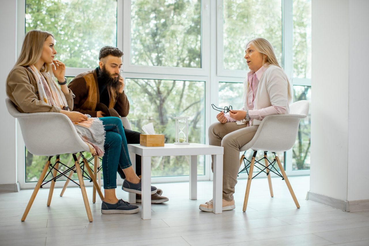 Couple sitting down talking to counselor